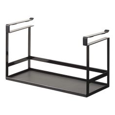 a black shelf with two metal handles and one is holding an empty tray on it