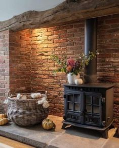 an old fashioned stove in front of a brick wall with potted plants on top