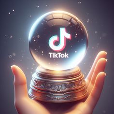 a person's hand holding a crystal ball with the tiktok logo on it