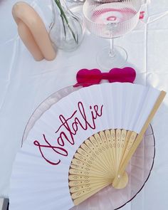 a table topped with a fan and vase filled with flowers