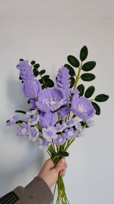 a person holding a bunch of purple flowers