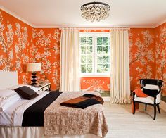 an orange and white bedroom with a chandelier hanging from the ceiling above it