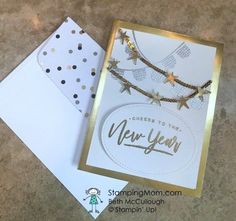 a new year's card with gold stars on it next to a white envelope