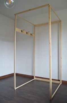 an empty room with a wooden frame on the floor and two lights hanging from the ceiling