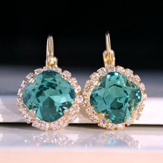 Sparkly, eye-catching, green crystal earrings will brighten up any outfit! Precision-cut crystals and unmatched, gorgeous colors are always show-stoppers! Details: * Premium European Crystals in Setting- 3/4"(18mm) * 14k Gold-Plated Lever Back Earrings * Earring Length- 1"(25mm) * Nickel and Lead-free These earrings come in a jewelry bag and box with ribbon. Turquoise Earrings Gold, Elegant Gold Necklace, Emerald Earrings Drop, Crystal Teardrop Earrings, Emerald Green Earrings, Box With Ribbon, Diamond Cluster Earrings, Bling Earrings, Bridesmaid Gifts Jewelry