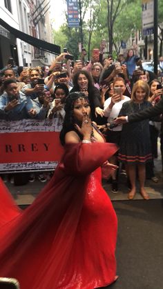 a woman in a red dress standing on the street