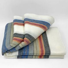 three towels folded on top of each other with multicolored stripes and white background