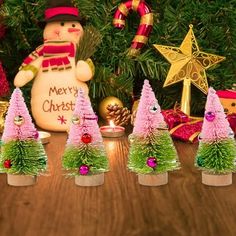 a group of small christmas trees sitting on top of a wooden table