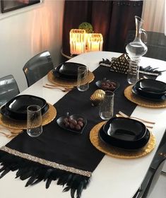 the table is set with black and gold place settings