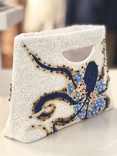 You’re heading to a beachside soirée or boarding a cruise ship bound for endless possibilities, and you reach for your glistening Hand-Beaded Octopus Clutch, adding an air of intrigue and mystique to your curated ensemble. Capturing the essence of seaside elegance, onlookers will be captivated by the playful októpus meticulously woven onto your coastal companion. Unveil your inner sea goddess and make waves while keeping your essentials tucked safely inside her satin lined interior.Model is also Luxury Beaded Elegant Clutch, Luxury Beaded Clutch, Elegant Luxury Beaded Clutch, Luxury Clutch Bags For The Beach, Luxury Pearl Embroidered Clutch, Beaded Octopus, Embroidery Purse, Sea Goddess, Pyrite Necklace