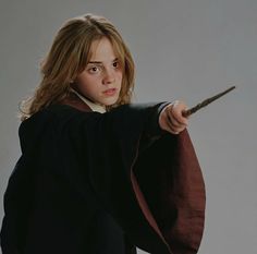 a woman holding a wand in her right hand