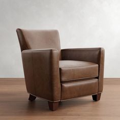 a brown leather chair sitting on top of a wooden floor