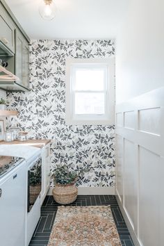 a kitchen area with a rug, sink and window