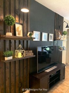 a flat screen tv sitting on top of a wooden shelf next to a wall mounted planter