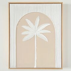 a white palm tree on a beige background in a wooden frame hanging on the wall