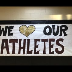 a banner that says we love our athletes with a heart in the center on it