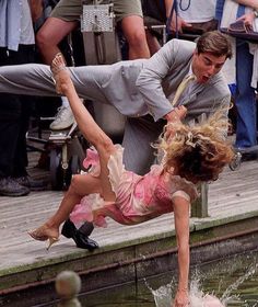 a man and woman are doing tricks in the water while people watch from the dock