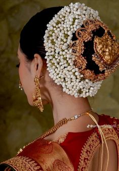 a woman wearing an elaborate head piece with pearls on it