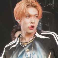 a young man with orange hair and piercings