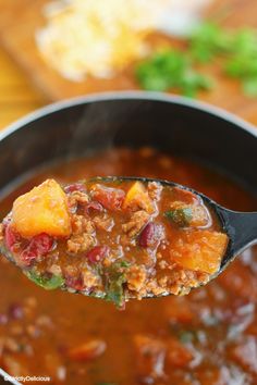 a spoon full of chili and meat soup