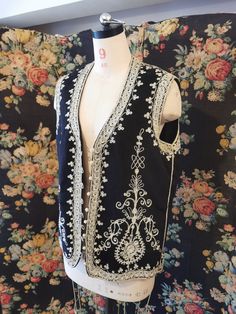 Black wool waistcoat with silver embroidery crewel work embellishment Across chest 21" Across waist 21 ½" Length from shoulder to hem 25" Elegant Embroidered Sleeveless Vest, Elegant Embroidered Festive Vest, Elegant Embroidered Fitted Vest, Elegant Fitted Embroidered Vest, Fitted Traditional Vest With Intricate Embroidery, Traditional Fitted Vest With Intricate Embroidery, Traditional Embroidered Fitted Vest, Fitted Embroidered Traditional Vest, Fitted Folk Style Festive Vest