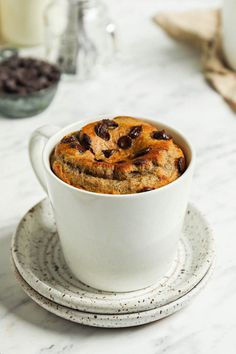 a cup filled with chocolate chip cookies on top of a plate