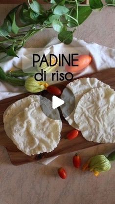 an image of some food on a cutting board with tomatoes and basil in the background