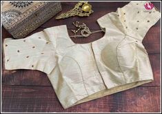 This is a cream color raw silk blouse with golden chumki work. This has a beautiful back neck with dori in the back and has a standard front opening. It fits size 40. It is a classy blouse perfect to pair with silk sarees. Size: 40 Please note: Color may vary slightly from the picture. Loose threads and pulled threads are common in embroidered clothing and it is not a defect. Elegant Raw Silk Blouse With Self Design, Gold Padded Blouse Choli For Designer Wear, Designer Gold Choli With Padded Blouse, Designer Wear Gold Choli With Padded Blouse, Gold Raw Silk Blouse For Navratri, Gold Semi-stitched Saree With Padded Blouse, Elegant Unstitched Dola Silk Blouse, Gold Raw Silk Blouse With Self Design, Gold Silk Blouse With Self Design