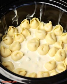 the crock pot is filled with dumplings and cream in it's slow cooker