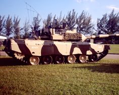 an army tank is parked in the grass