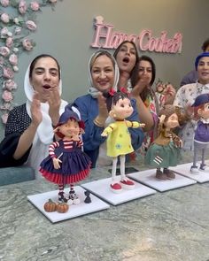 a group of people standing next to each other in front of a table with figurines on it