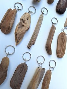 several wooden keychains are arranged on a white surface, including one with a piece of wood in the middle