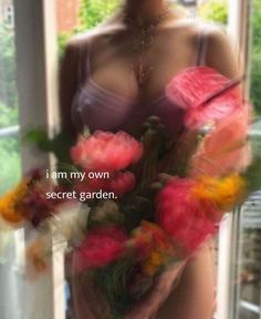 a woman holding flowers in her hands with the words i am my own secret garden