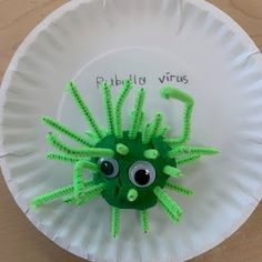 a paper plate with a green creature on it