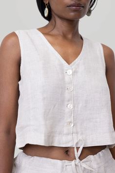 Revive 90s nostalgia with our Reistor Textured Linen Cropped Vest Top, a timeless design that perfectly blends retro charm with contemporary style. This V-neck vest features a regular fit and shell buttons at the front, exuding a classic yet trendy appeal. Embrace the versatility of this piece, ideal for pairing with skirts,pants or shorts for summer outings or layering under jackets for a chic look. Wash in cold water or dry clean only, Do not soak bleach or wring, Line dry in shade, Iron insid Cropped Vest Top, Pajamas Aesthetic, Shorts For Summer, Vest Crop Top, Linen Crops, Cropped Vest, 90s Nostalgia, Shell Buttons, Vest Shirt