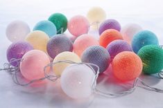 there are many balls that have been placed on the table together with string lights attached to them