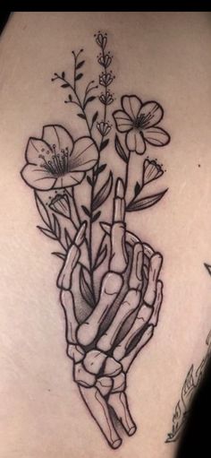 a black and white photo of a tattoo with flowers in the shape of a hand