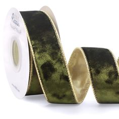 a roll of green and gold foiled ribbon on a white background with black dots