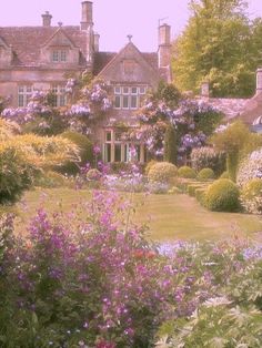 a large house with lots of flowers in the front yard