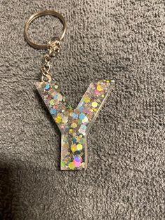 the letter y is made up of tiny confetti and silver flecks