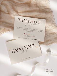 two folded cards with the words thank you and handmade written on them next to a white blanket