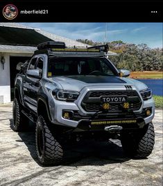 a silver toyota truck parked in front of a house