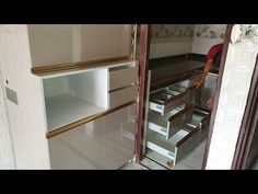 a man is standing in the doorway of a room with shelves and drawers on it