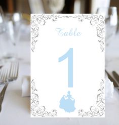 a table number is shown with silverware on the place card for guests to sit at