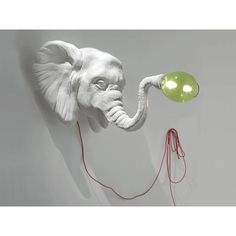 an elephant lamp with a green light on it's head and two red cords attached to the wall