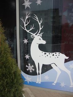 a window with a white deer and snowflakes on it