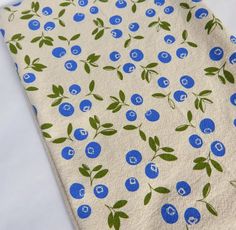 a blueberry print fabric with green leaves on it