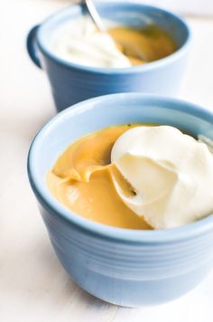 two blue bowls filled with food on top of a table