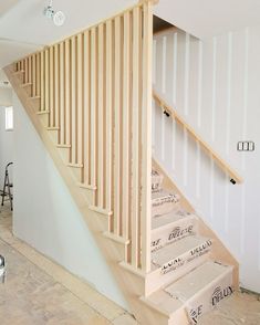 a staircase being built in a house with white walls and wood handrails on each side