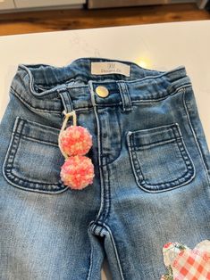 a pair of jeans with pom - poms attached to them